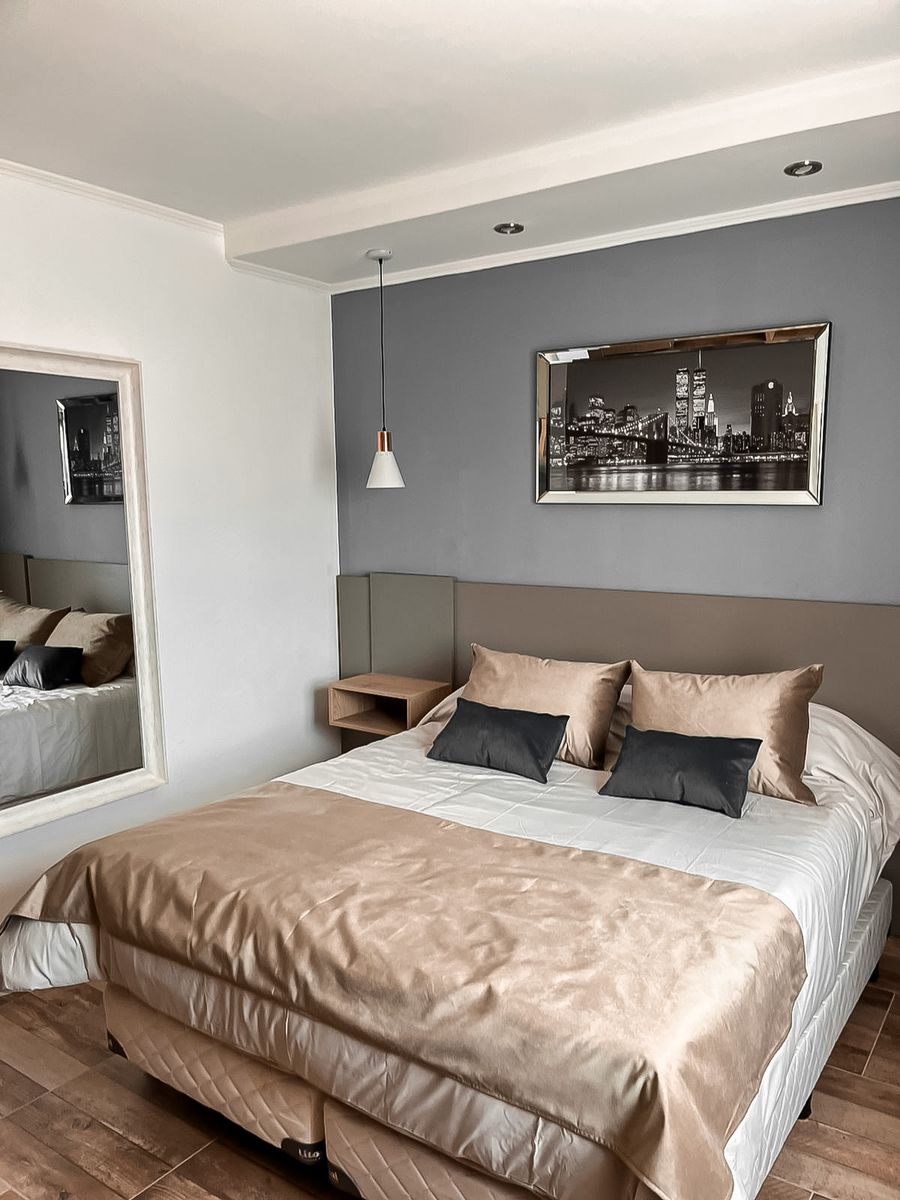 Suite con cama matrimonial y espejo de cuerpo entero